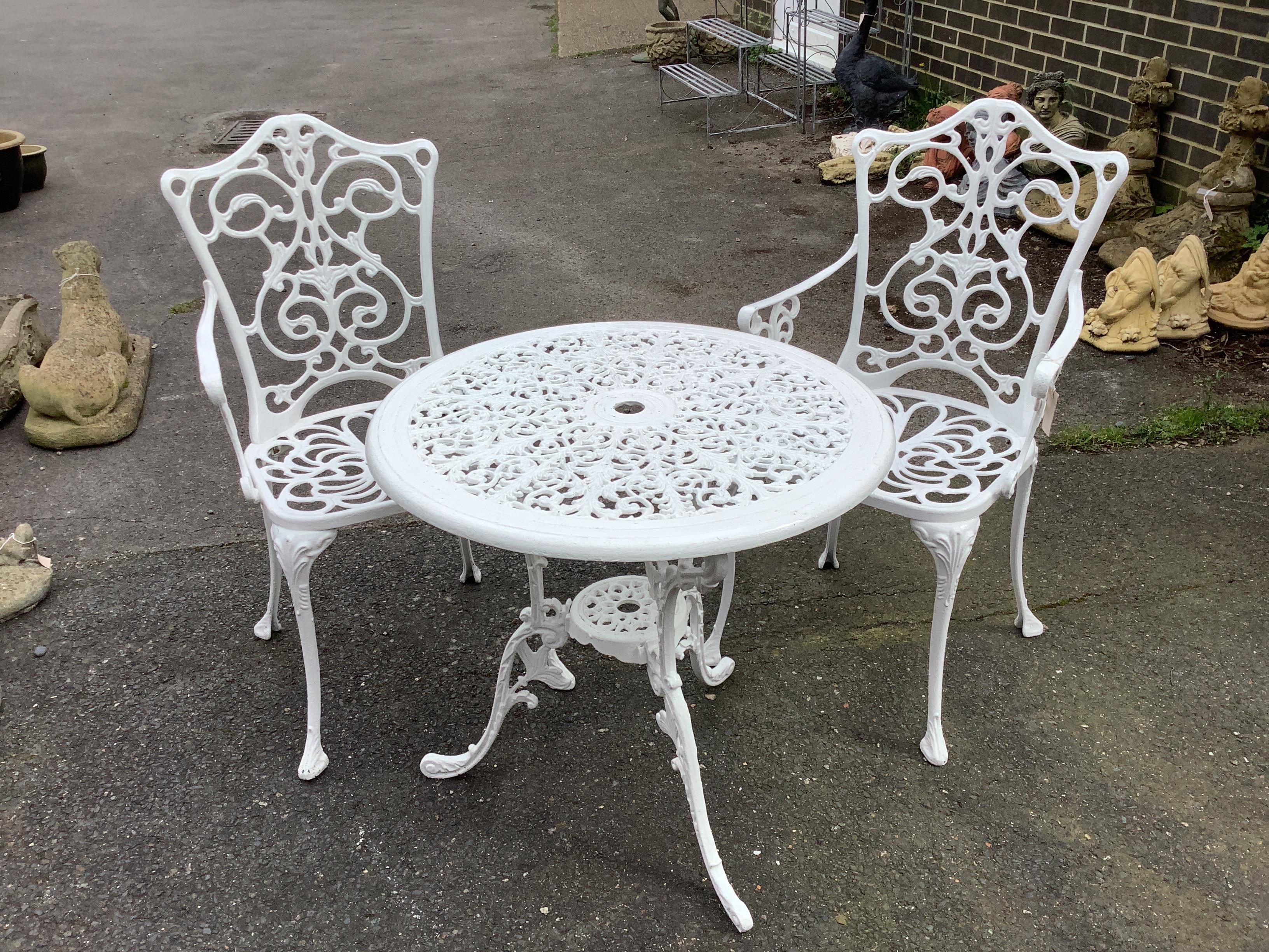 A Victorian style painted aluminium circular garden table, diameter 68cm, height 65cm together with two similar painted chairs (one a.f.)